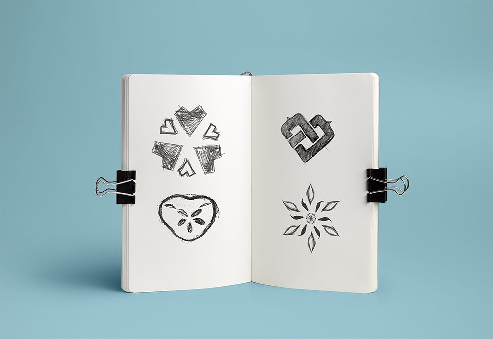 Open sketchbook filled with hand-drawn logo mark explorations